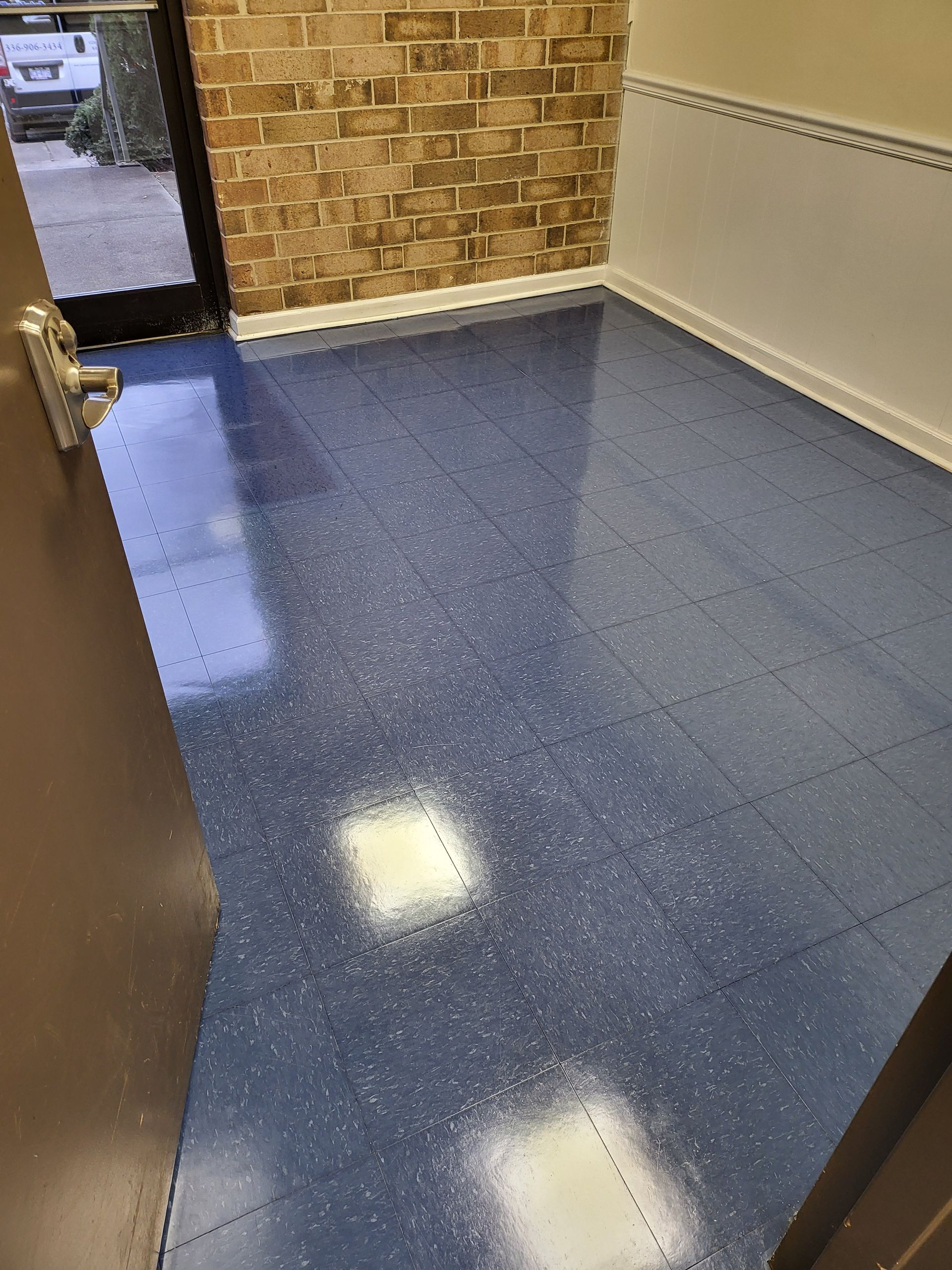 A room with a blue tile floor and a brick wall.