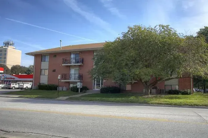 a brick apartment building with a gas station in the background .