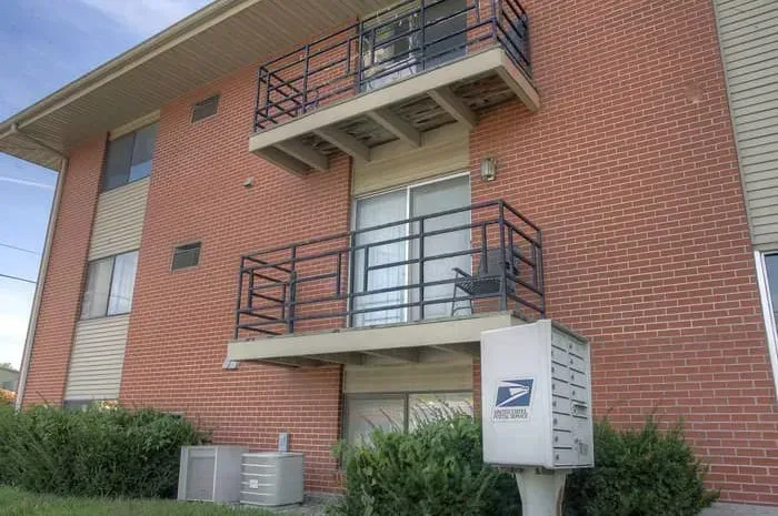 a brick building with a balcony and a mailbox in front of it .