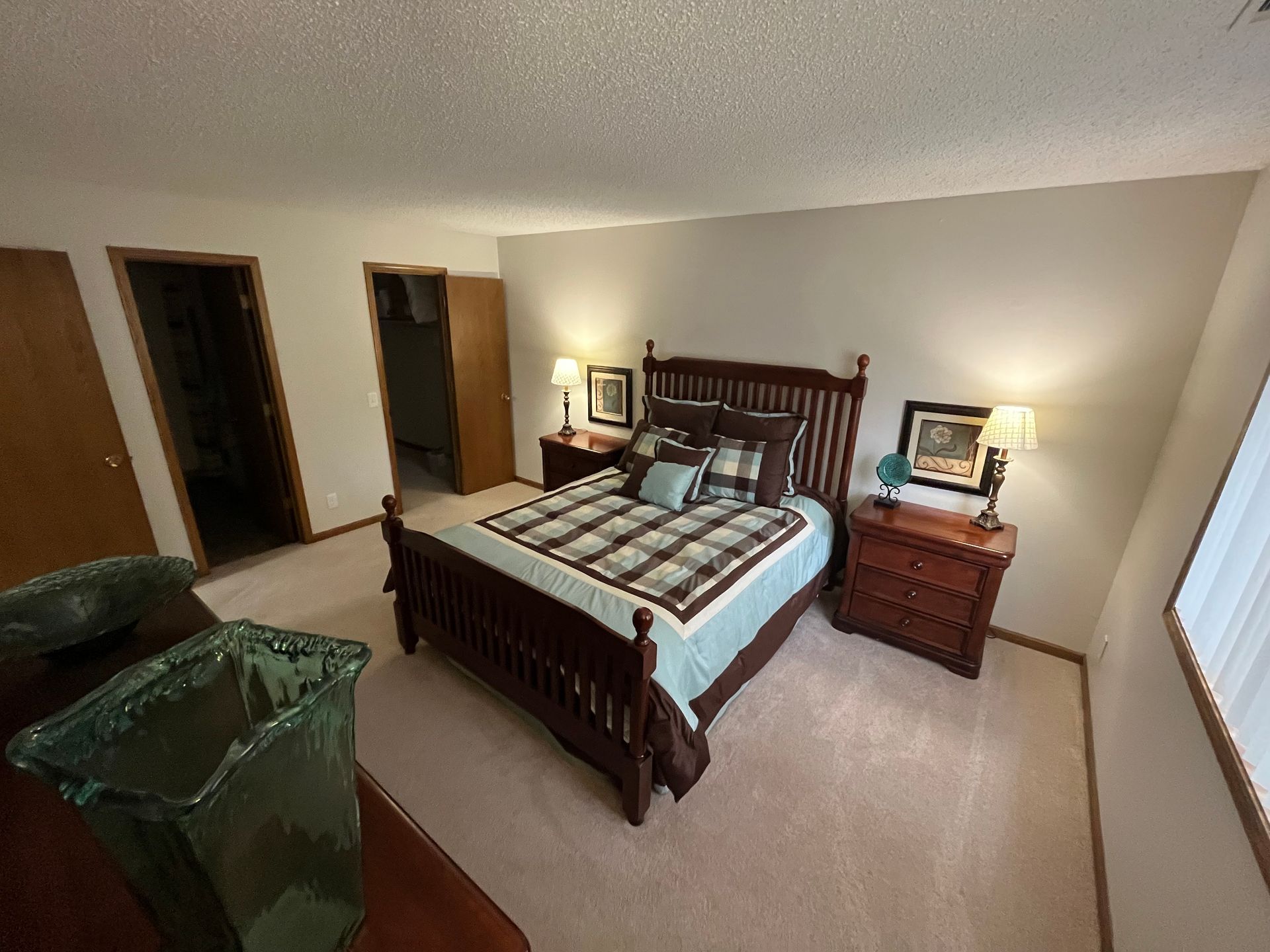 a bedroom with a king size bed , nightstands , and a trash can .