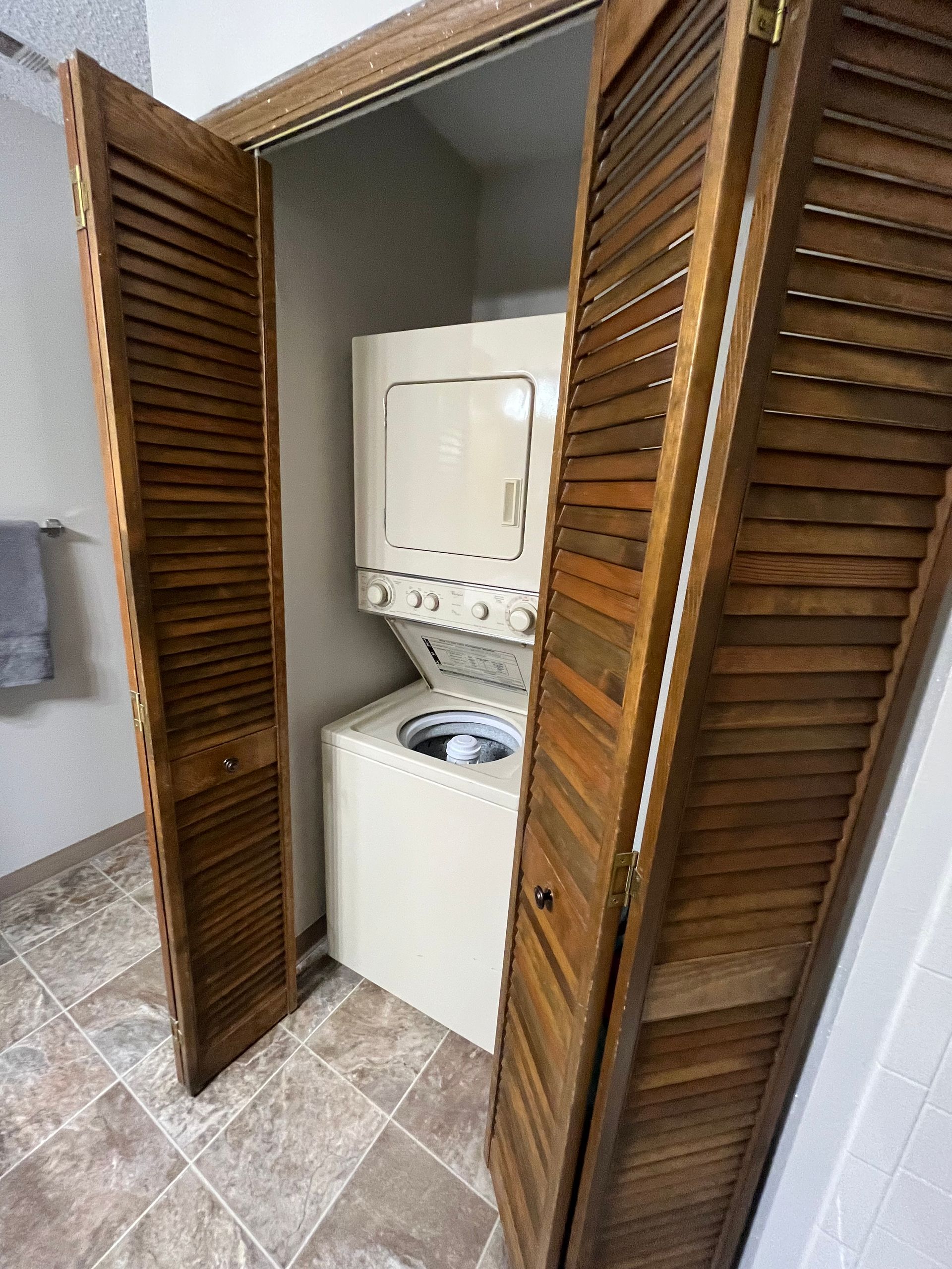 a washer and dryer are stacked on top of each other in a closet .