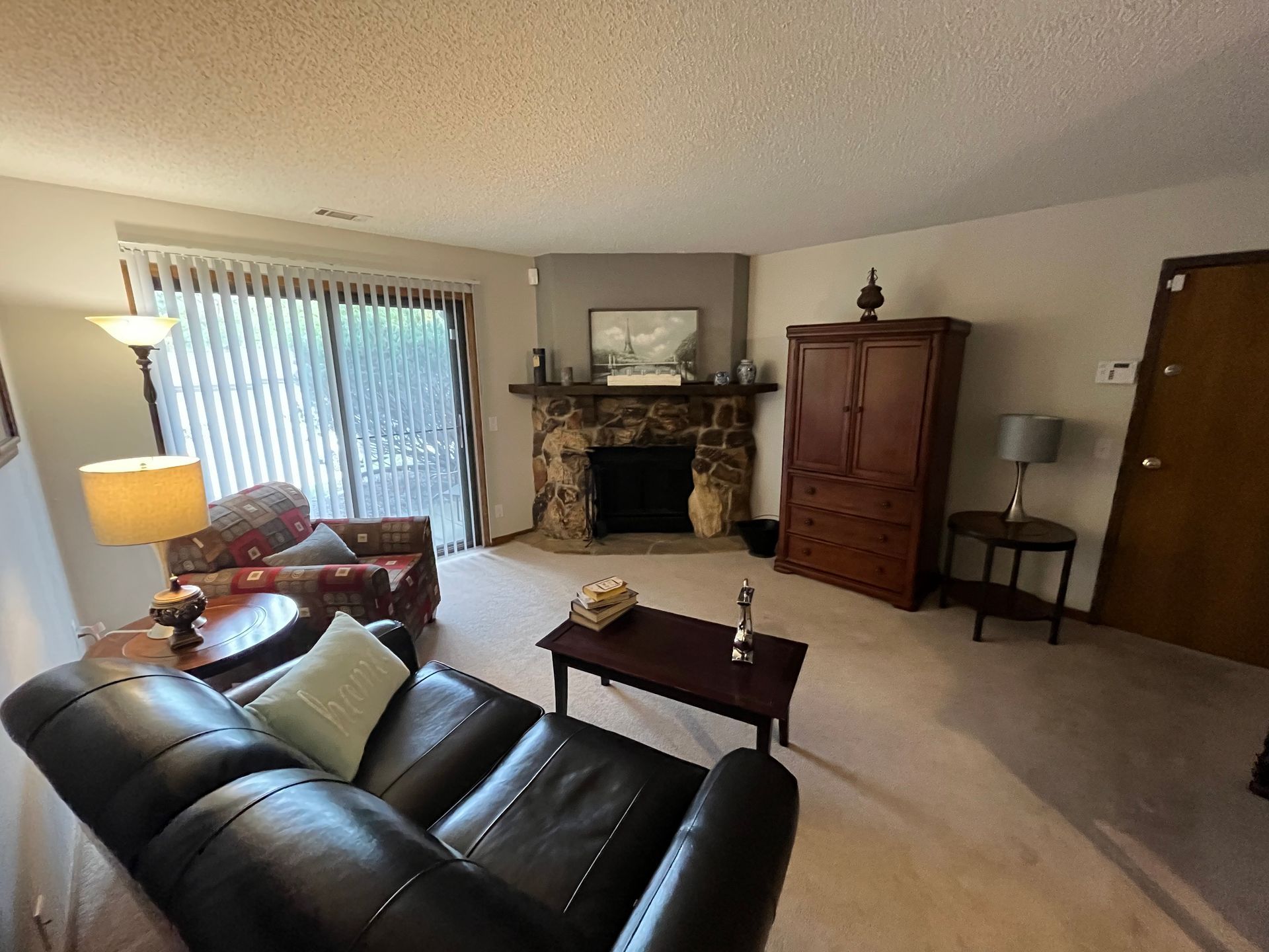 a living room with a couch , chair , coffee table and fireplace .