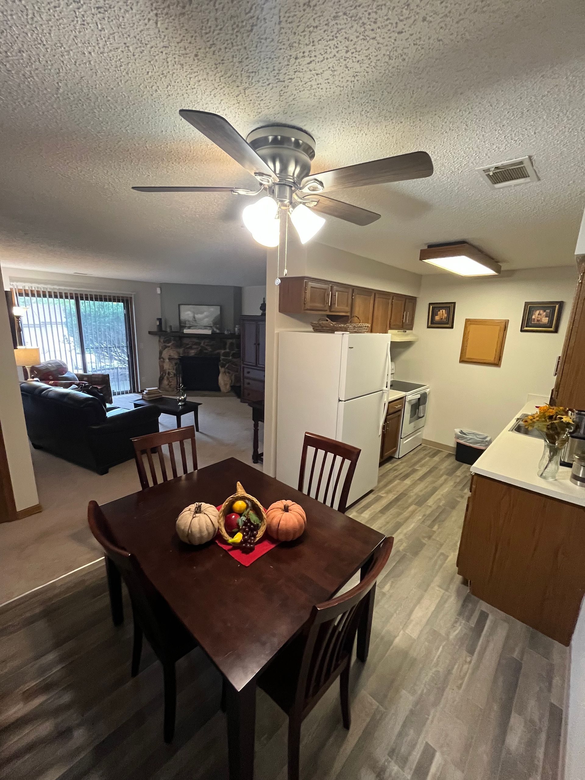 a dining room table with pumpkins on it and a ceiling fan .