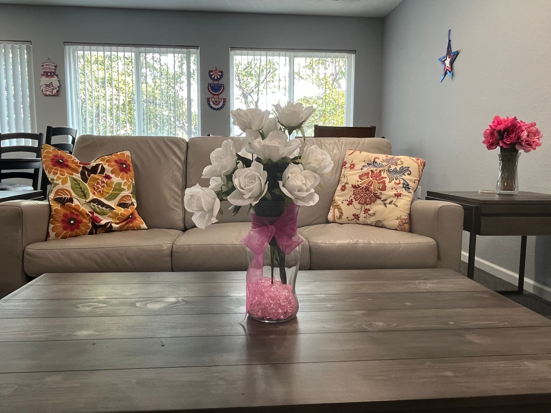 a living room with a couch and a vase of flowers on the table