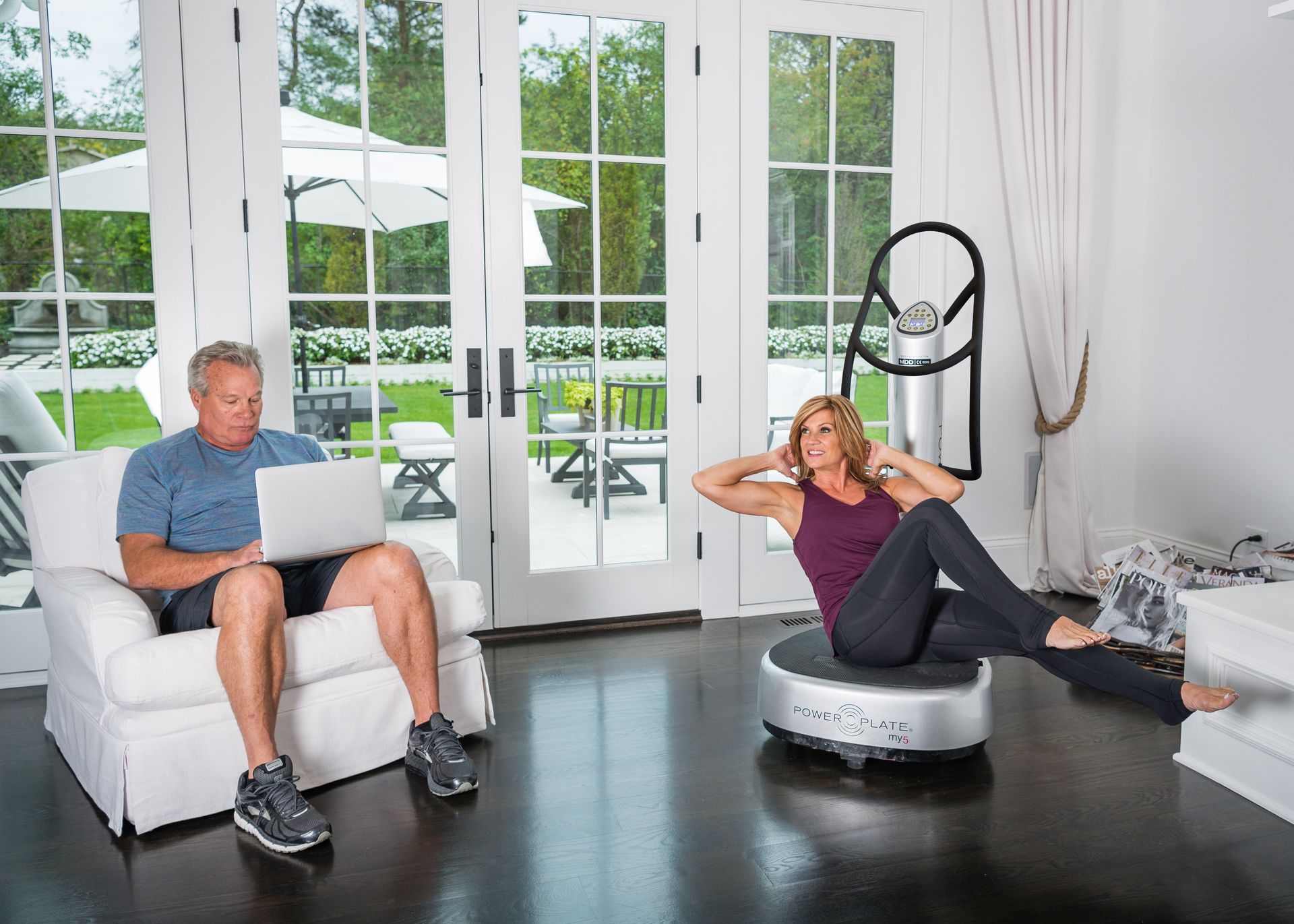 A man is sitting in a chair while a woman is doing exercises on a platform.