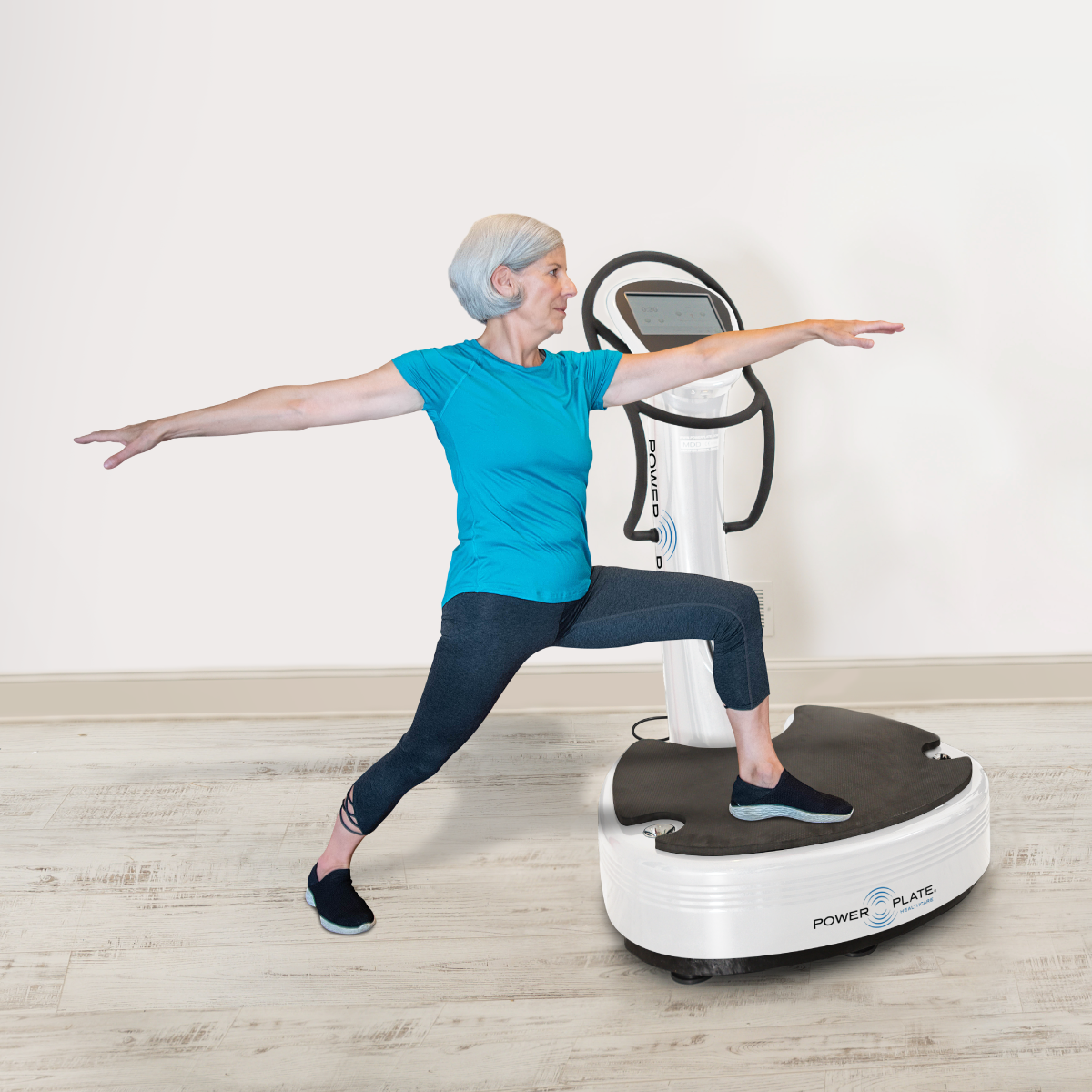 An older woman is doing a yoga pose on a machine.