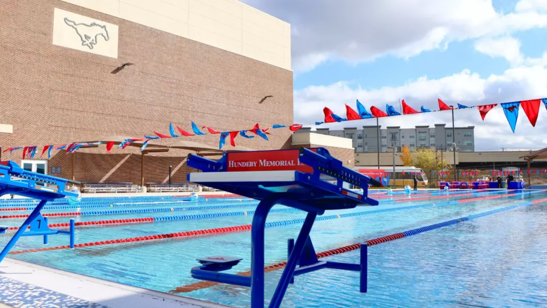 A swimming pool with a large building in the background