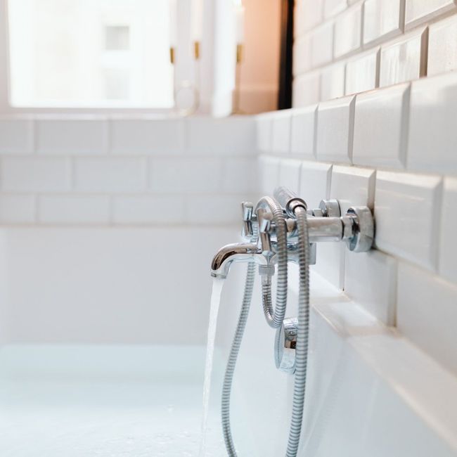 a bathtub with water running from the faucet