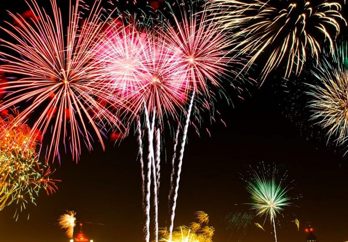 Fireworks exploding in various colors against a dark night sky.