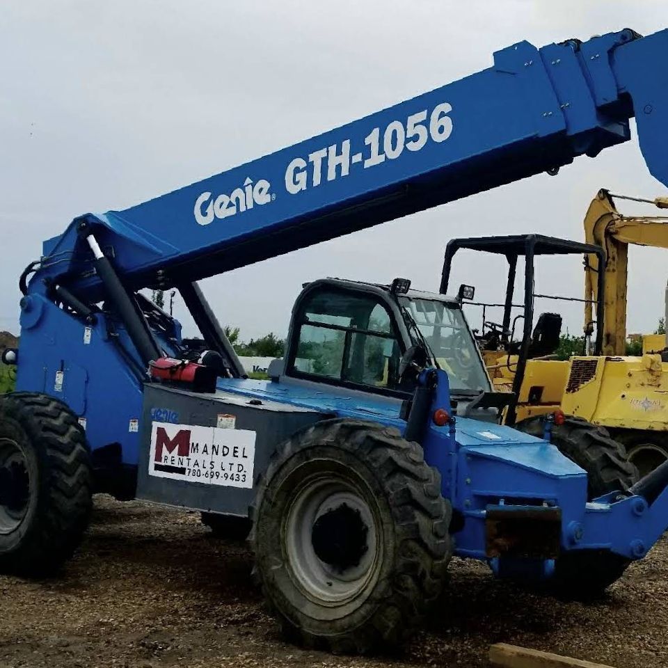 a blue genie gth-1056 boom lift is parked next to a yellow excavator