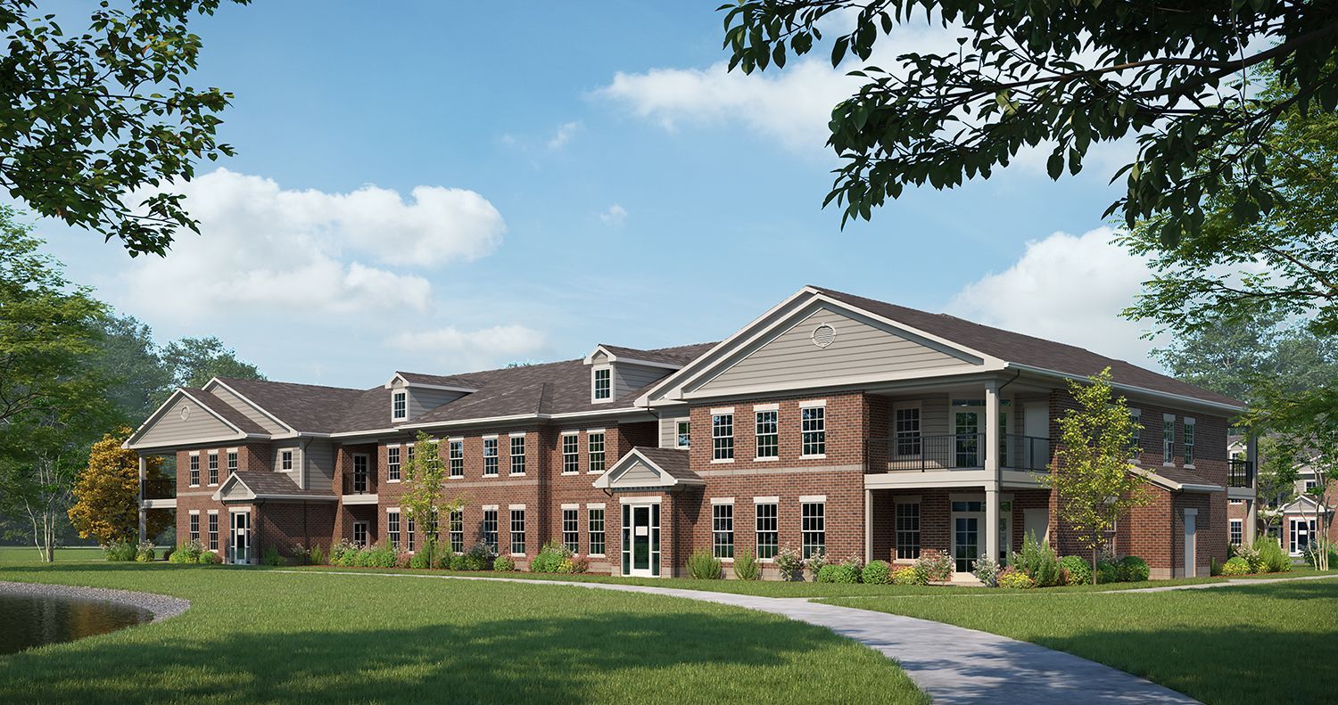 a large brick building with a walkway leading to it at Woods of West Carmel in Zionsville, IN.