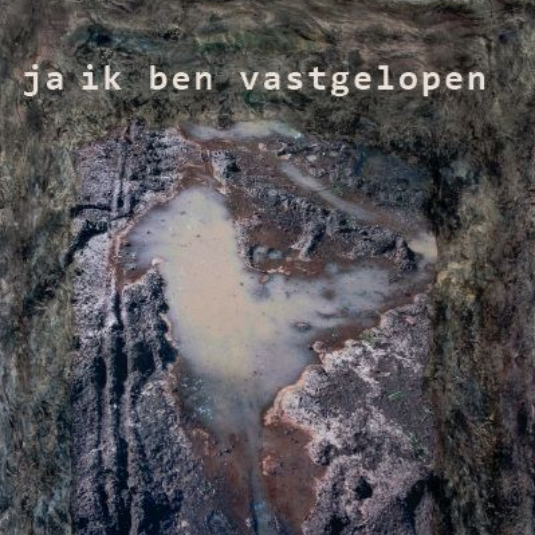 Een modderige, uitgegraven kuil of steengroeve met de Nederlandse tekst 