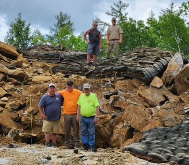 A yellow and white construction vehicle is sitting in the snow.