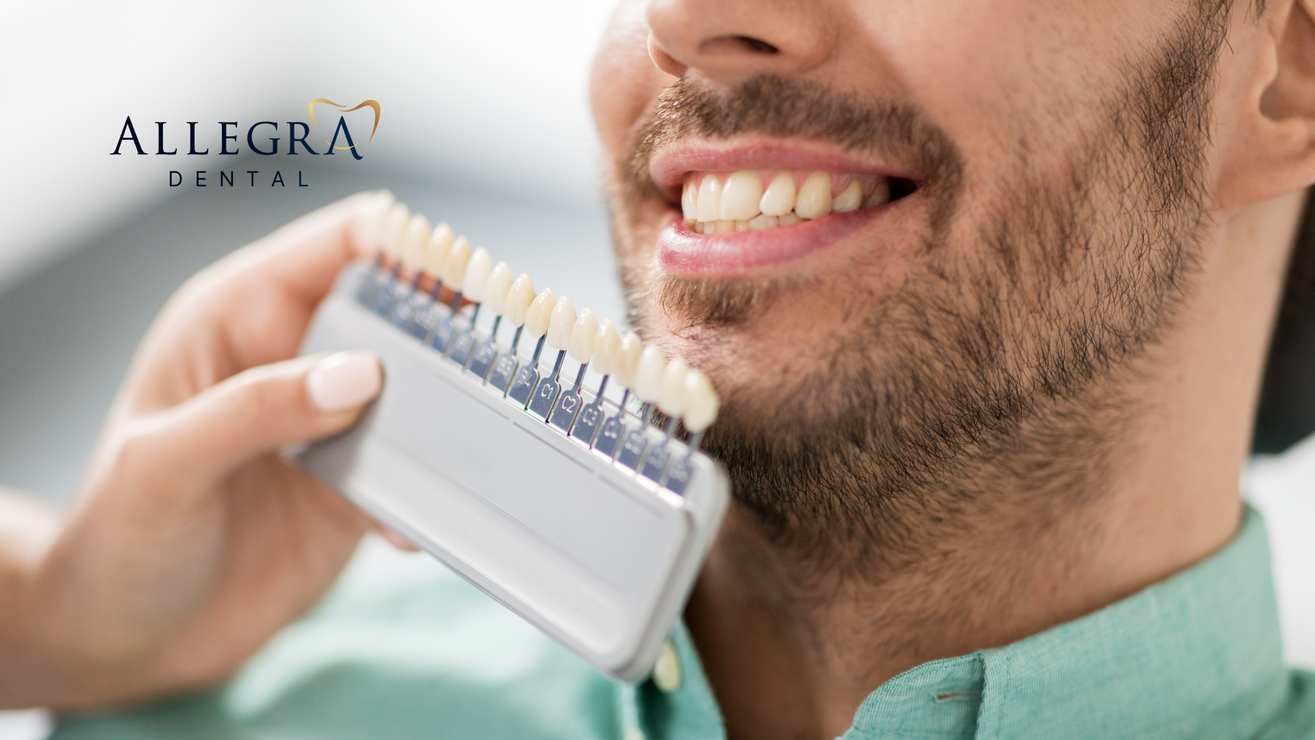 A man is holding a tooth color chart in front of his mouth.