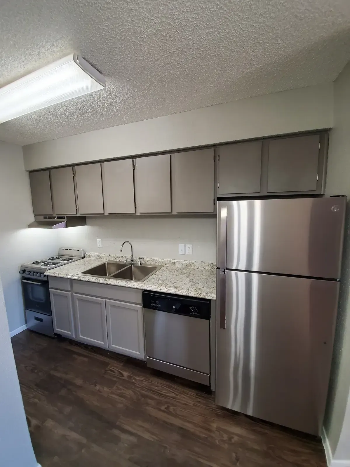 A kitchen with stainless steel appliances and gray cabinets