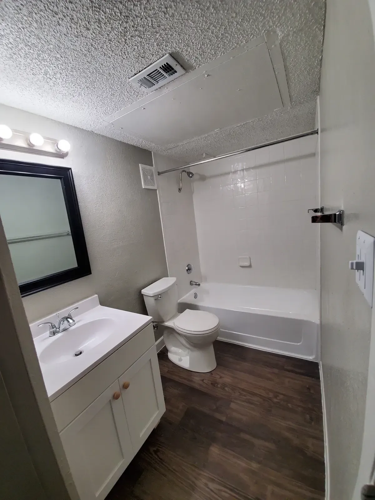 A bathroom with a sink , toilet , bathtub and mirror.