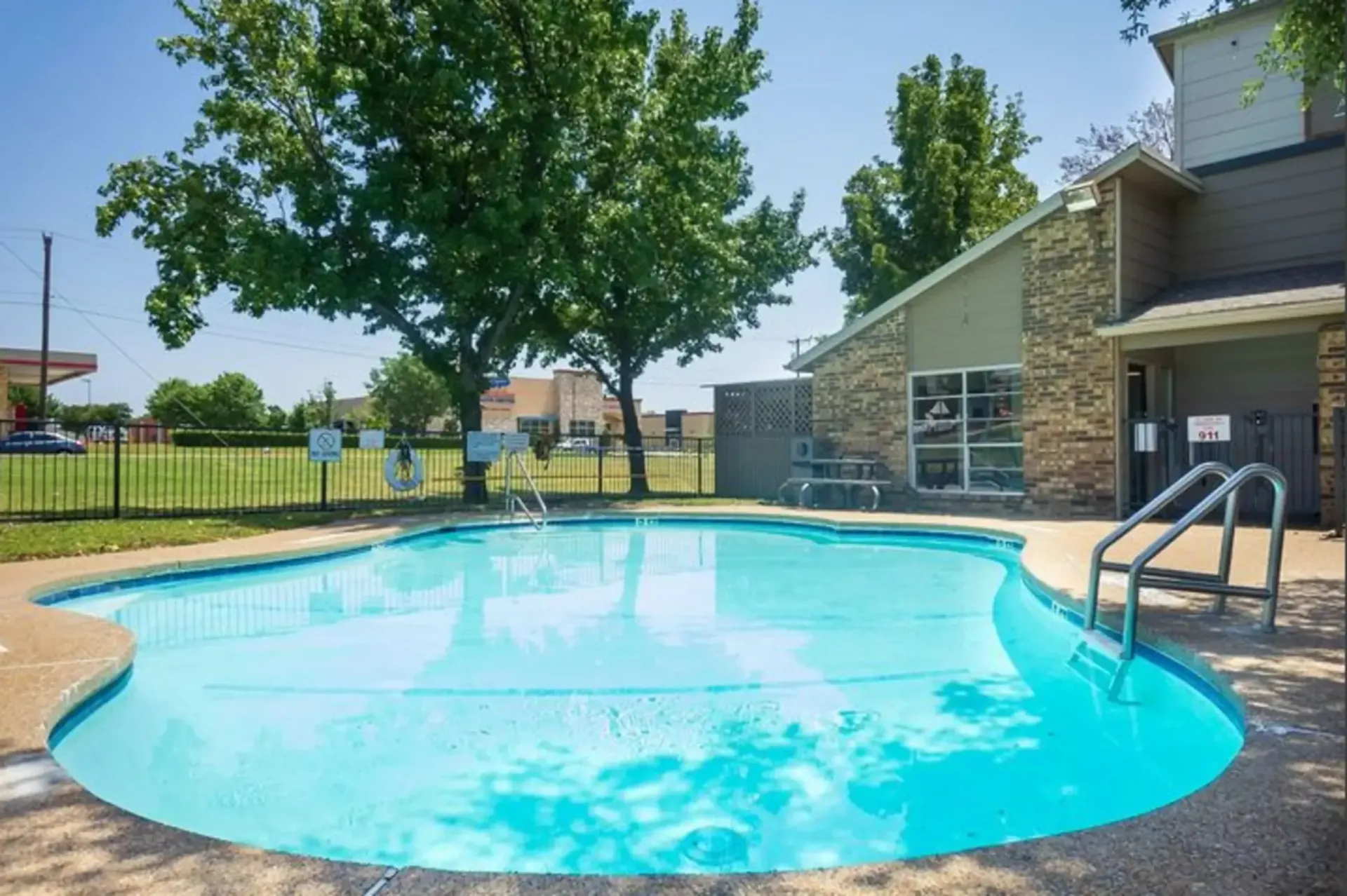 A large swimming pool with stairs leading to it in front of a building.