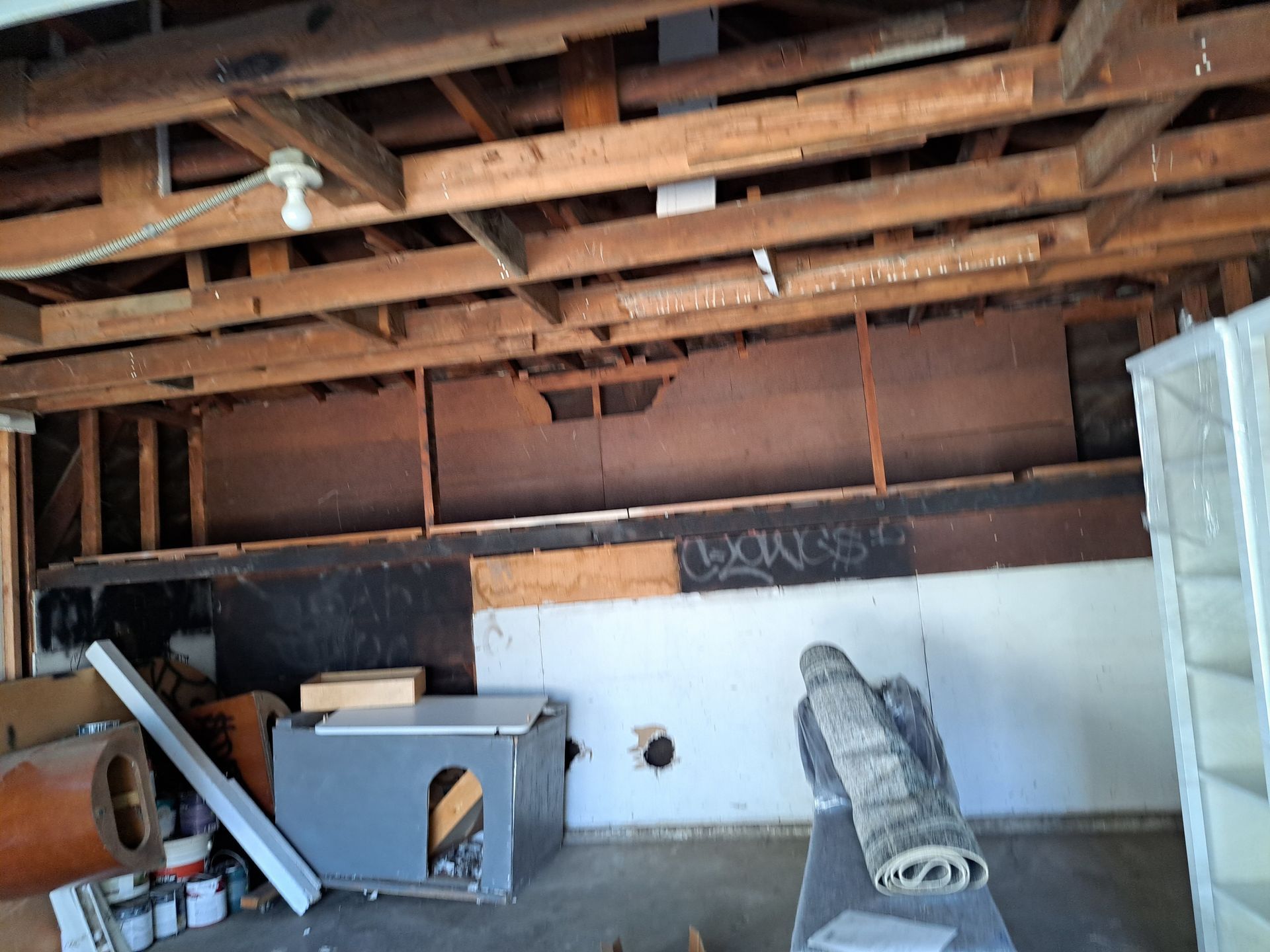A room with wooden beams and a rug on the floor