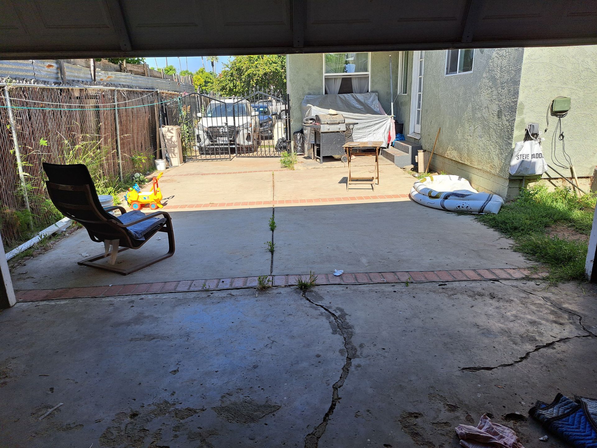A patio with a chair and a table under a garage door.