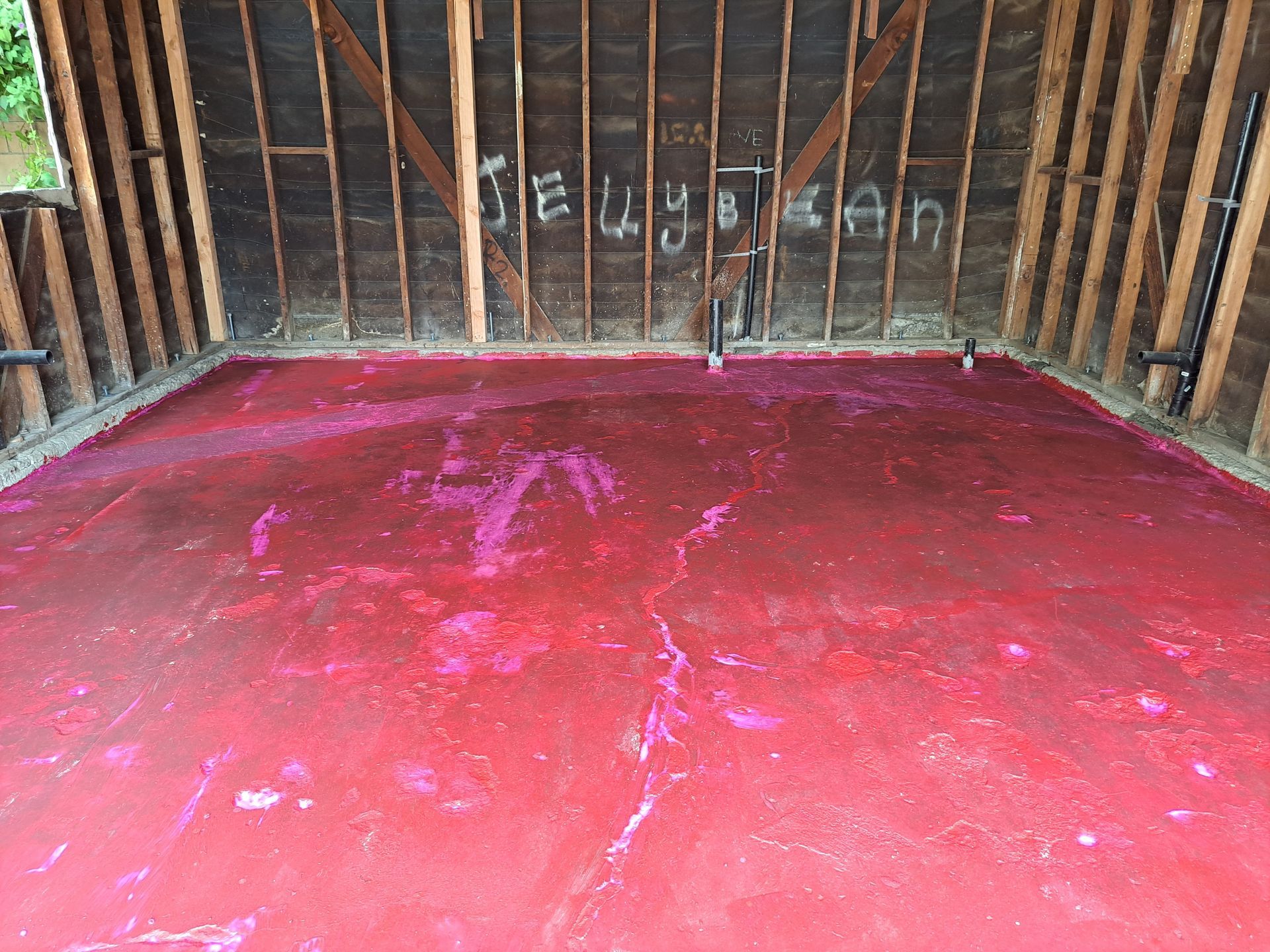A room with a red floor and a wall with the word jesus written on it