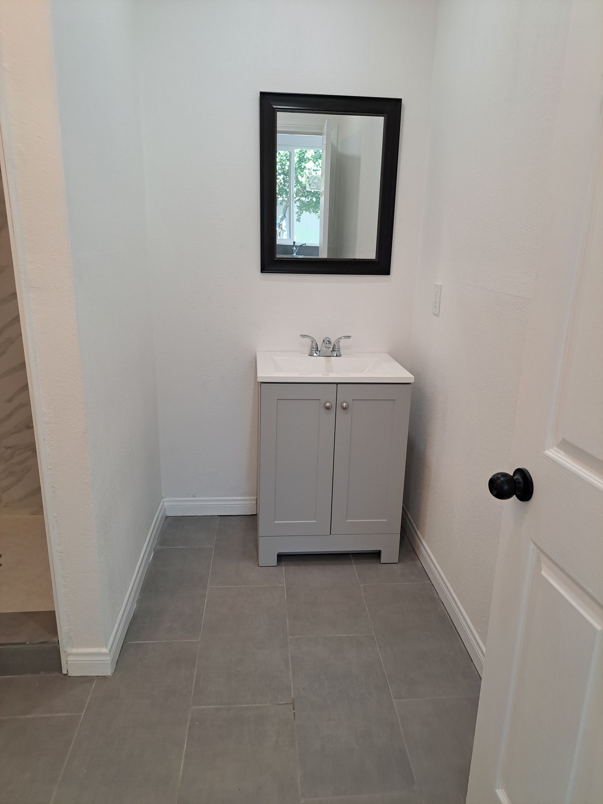 A bathroom with a sink and a mirror on the wall.