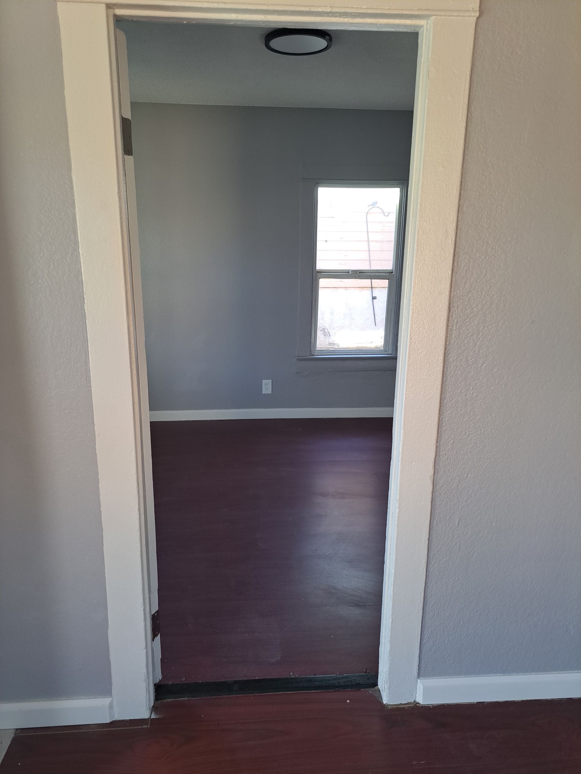 A doorway leading into an empty room with a window.