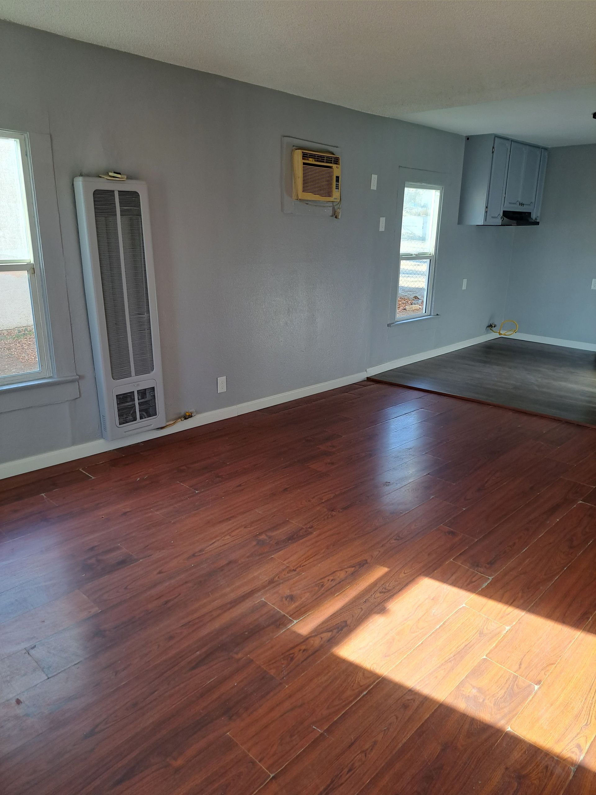 A living room with hardwood floors and a window.