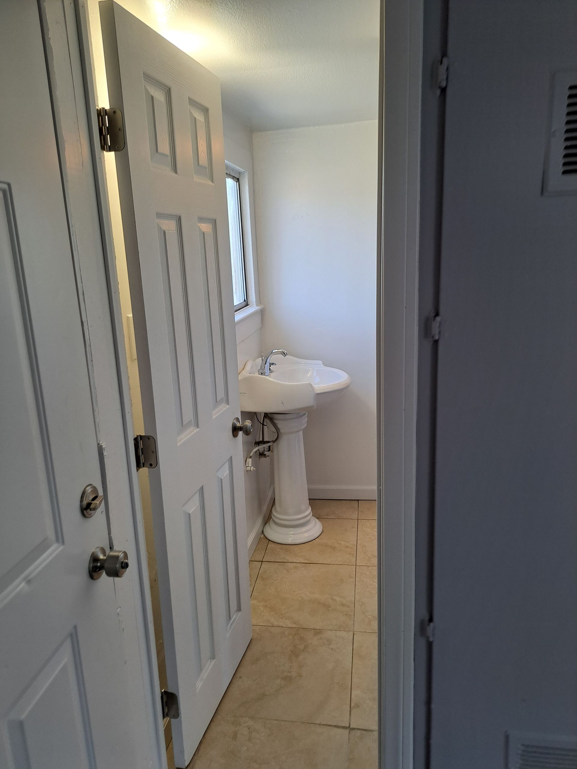 A bathroom with a sink and a door leading to it.