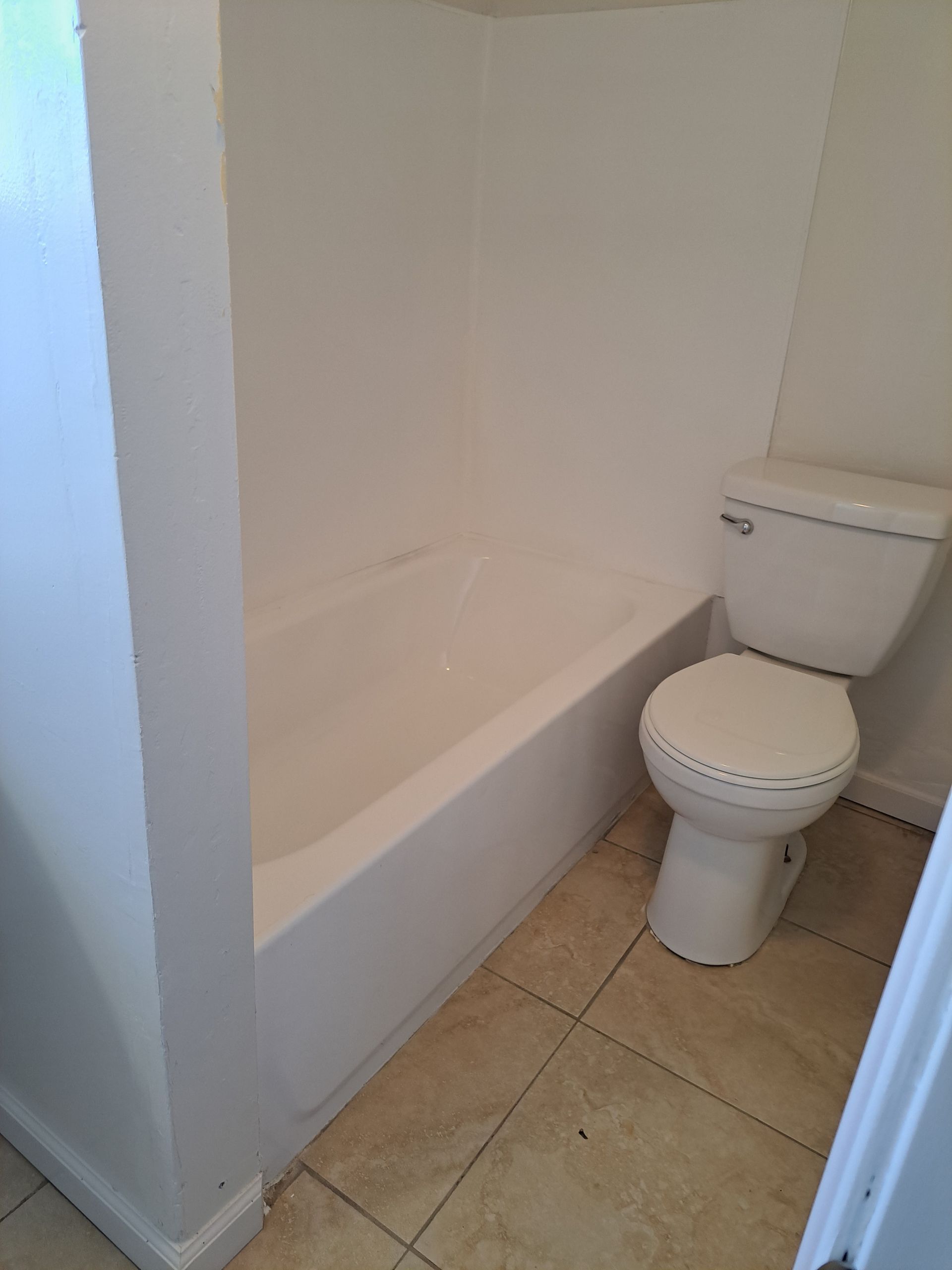 A bathroom with a toilet and a bathtub.