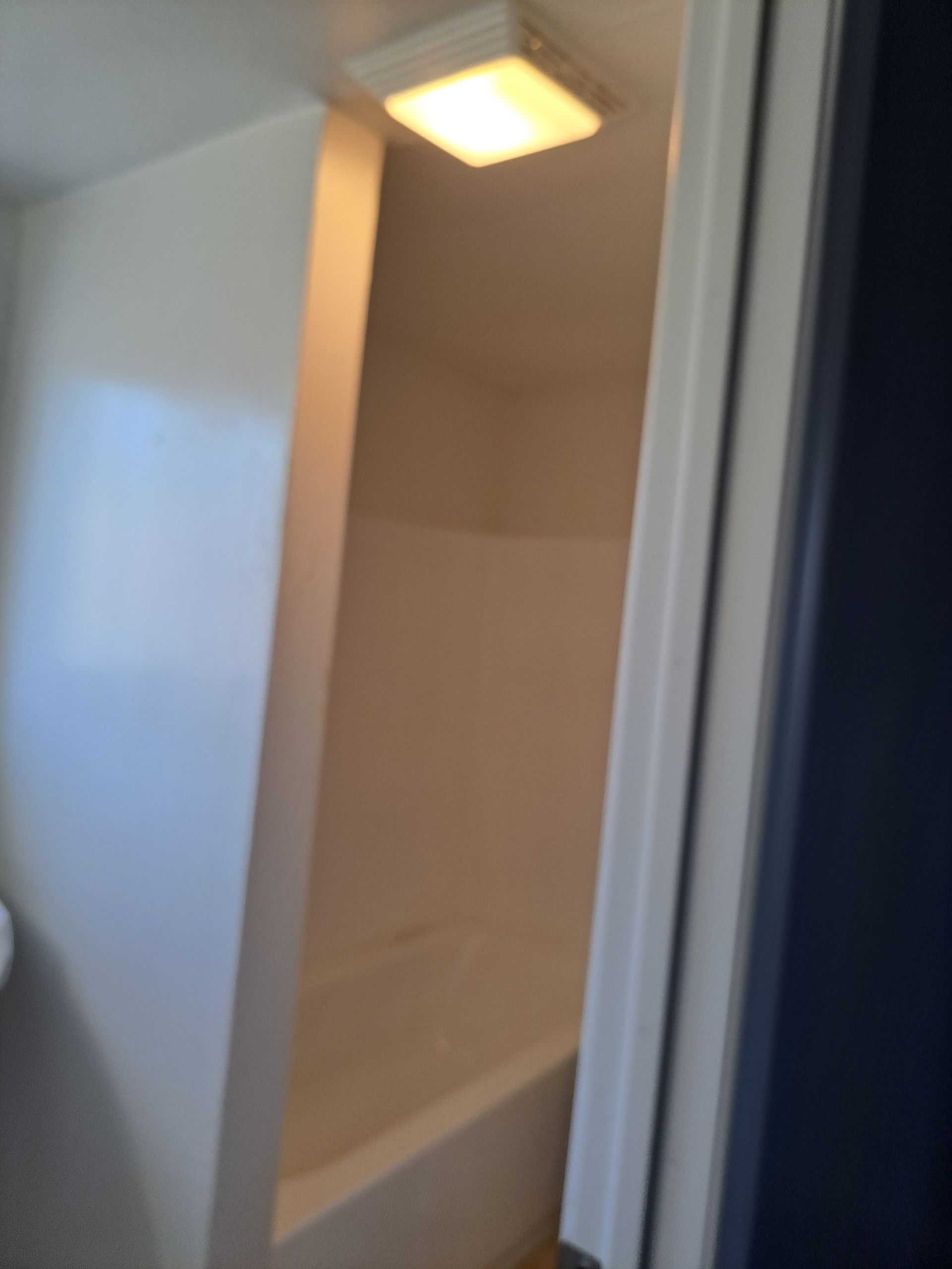 A bathroom with a bathtub and a light on the ceiling.