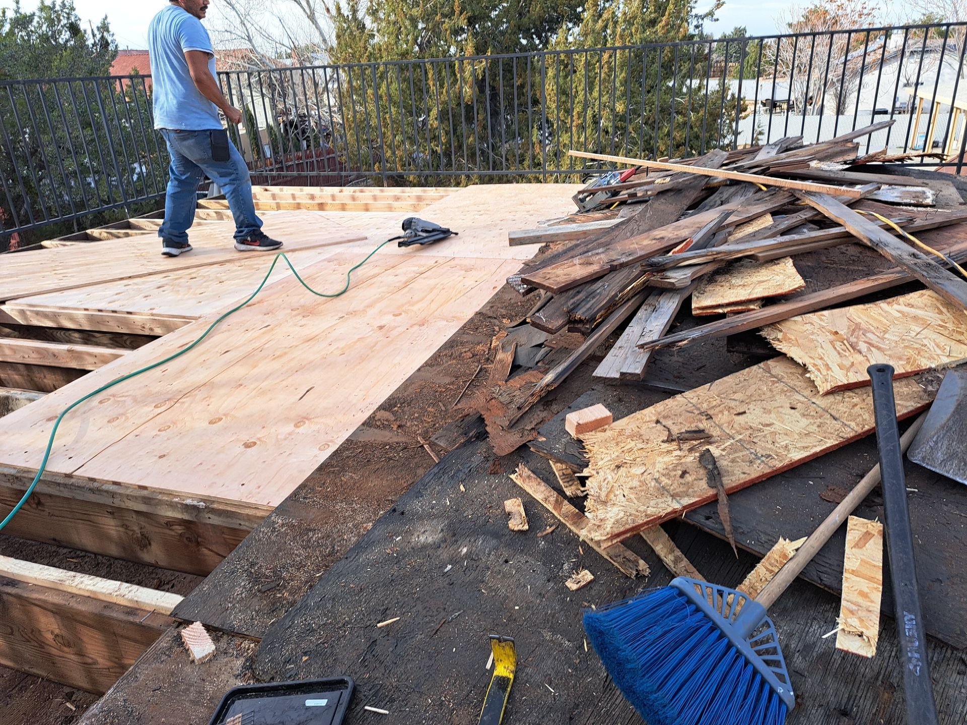 A man is standing on top of a pile of wood.