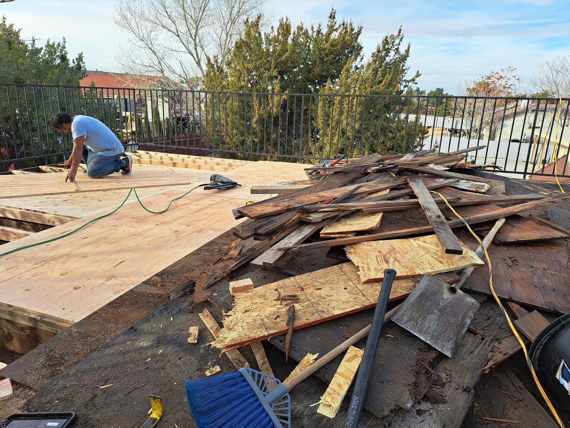 A man is working on a roof with a hose.