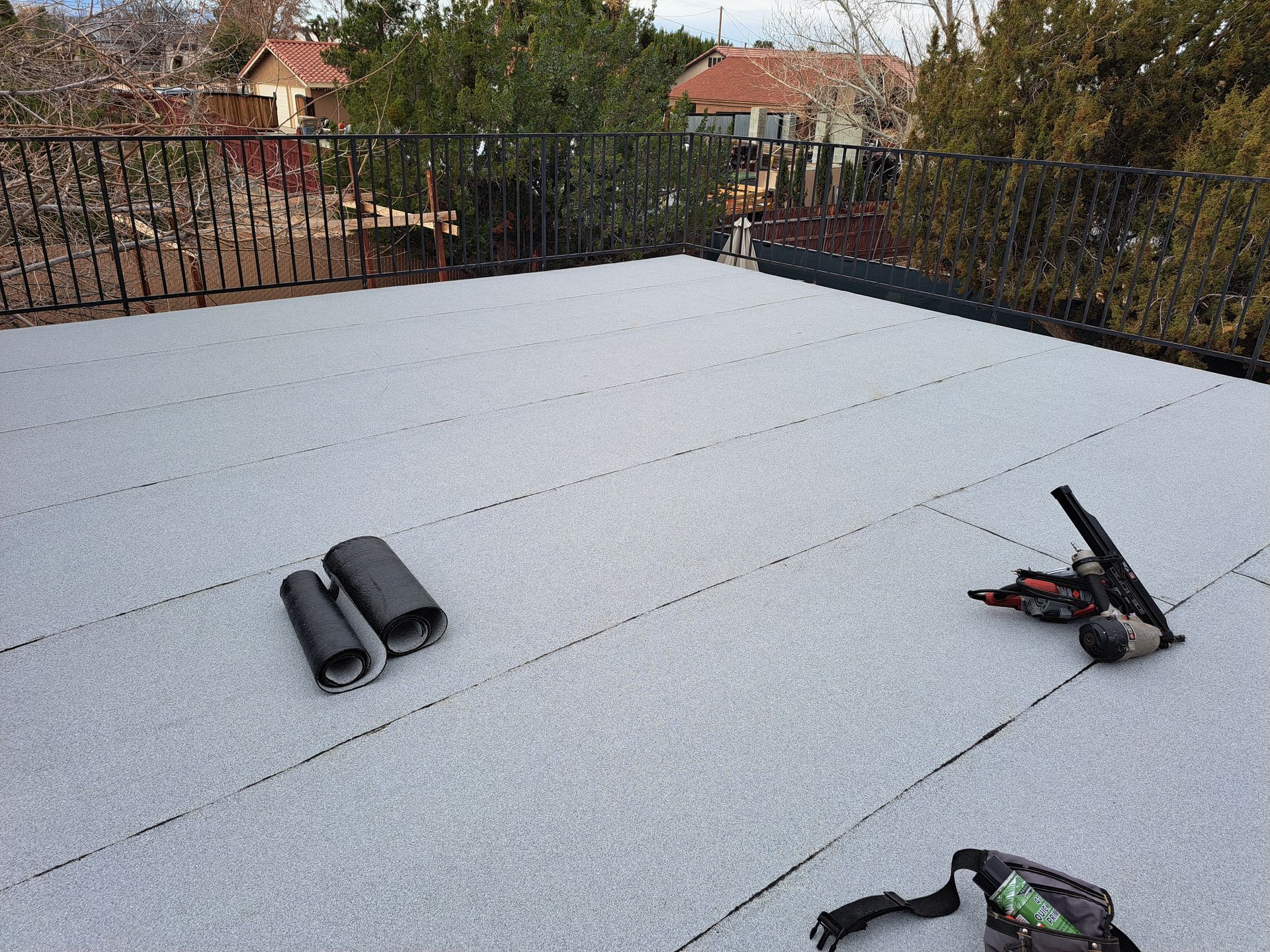 A roof with a bag and tools on it.