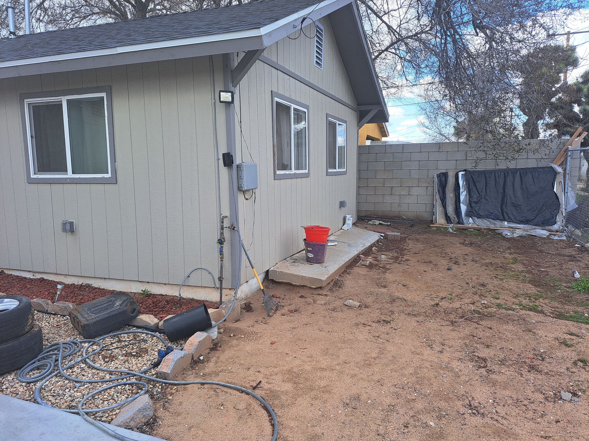 A small house with a red bucket in front of it.