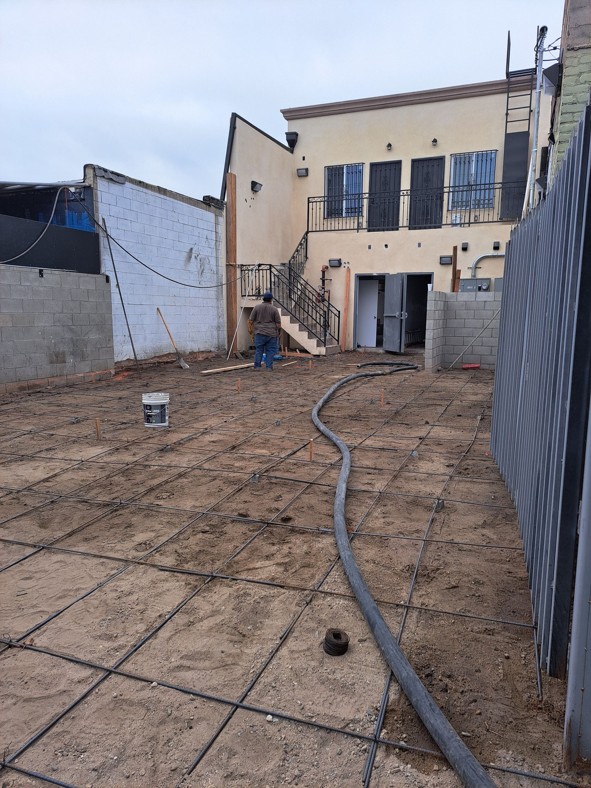 A hose is laying in the dirt in front of a building