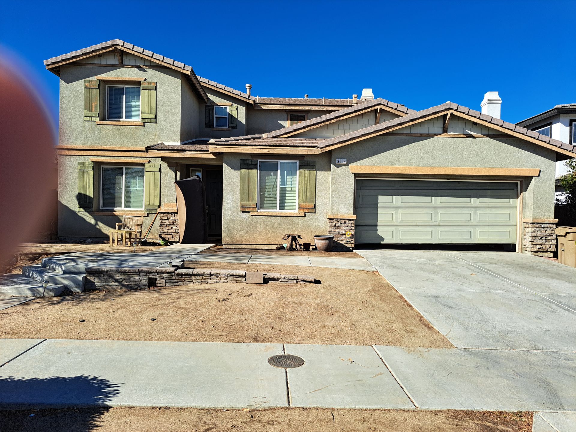 A large house with two garage doors and a concrete driveway