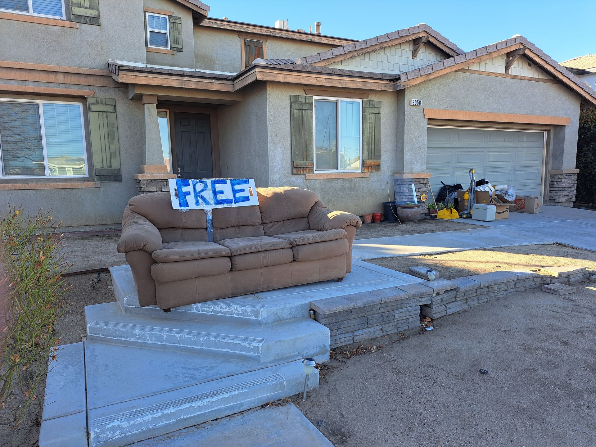A free couch is sitting in front of a house.