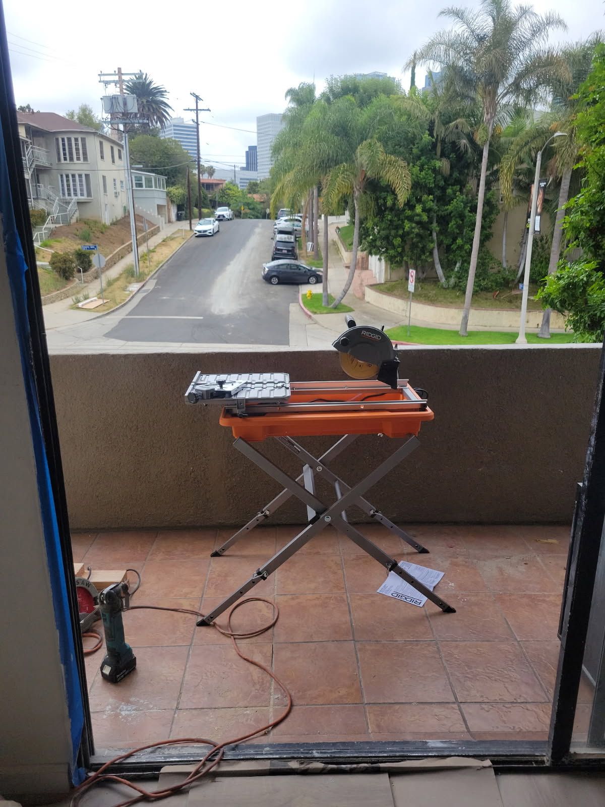 A circular saw is sitting on a table on a balcony.