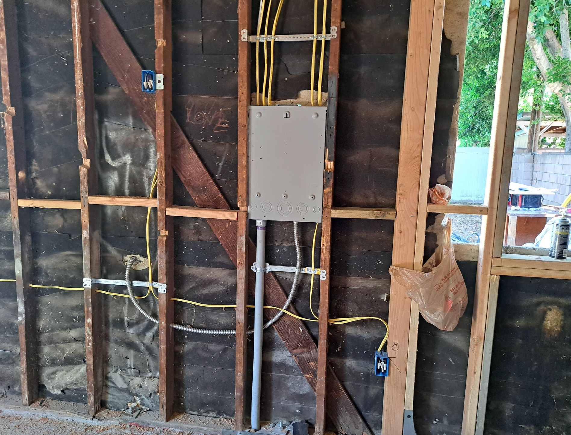 A wooden wall with electrical wires coming out of it