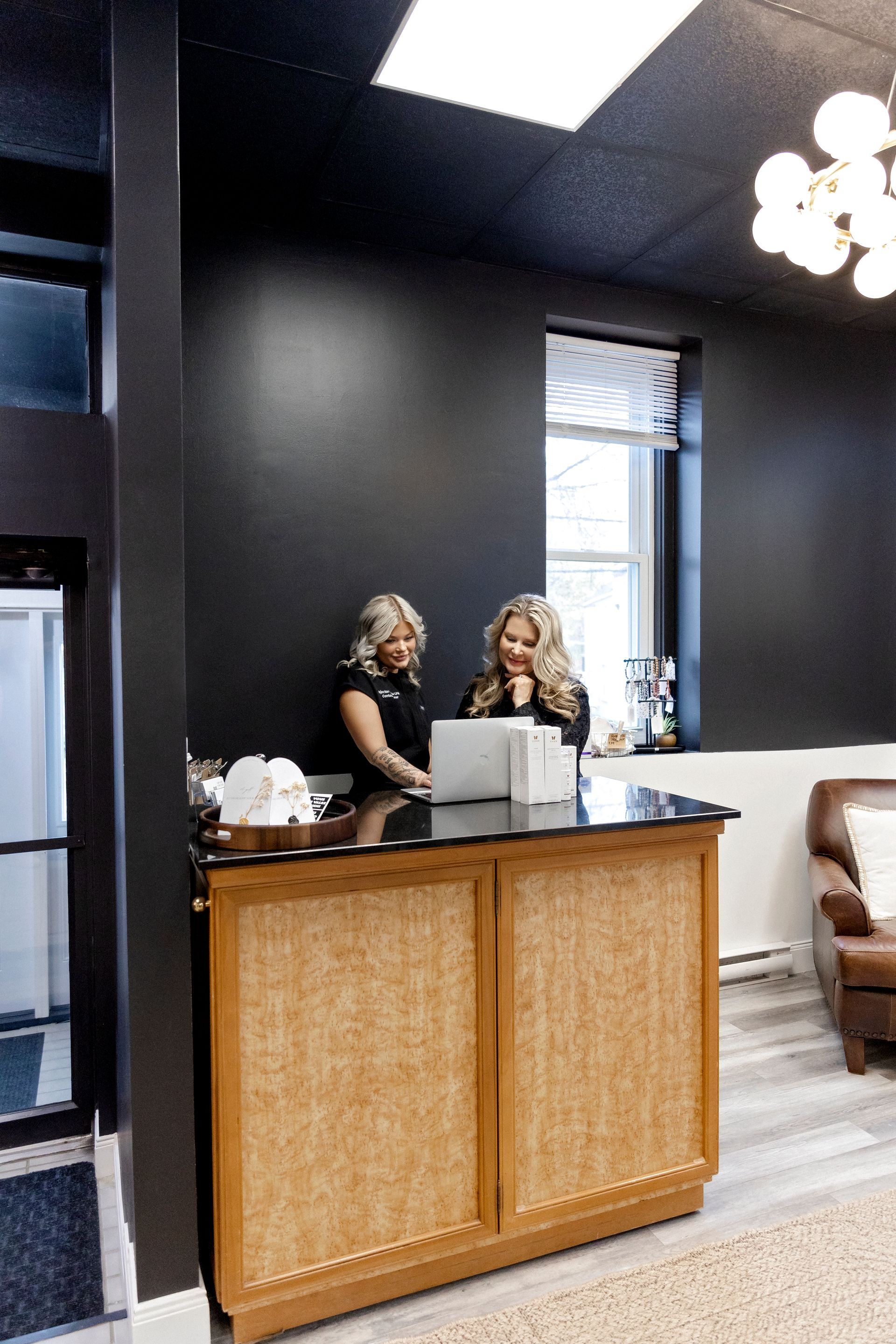 Two women are sitting at a counter in a room.