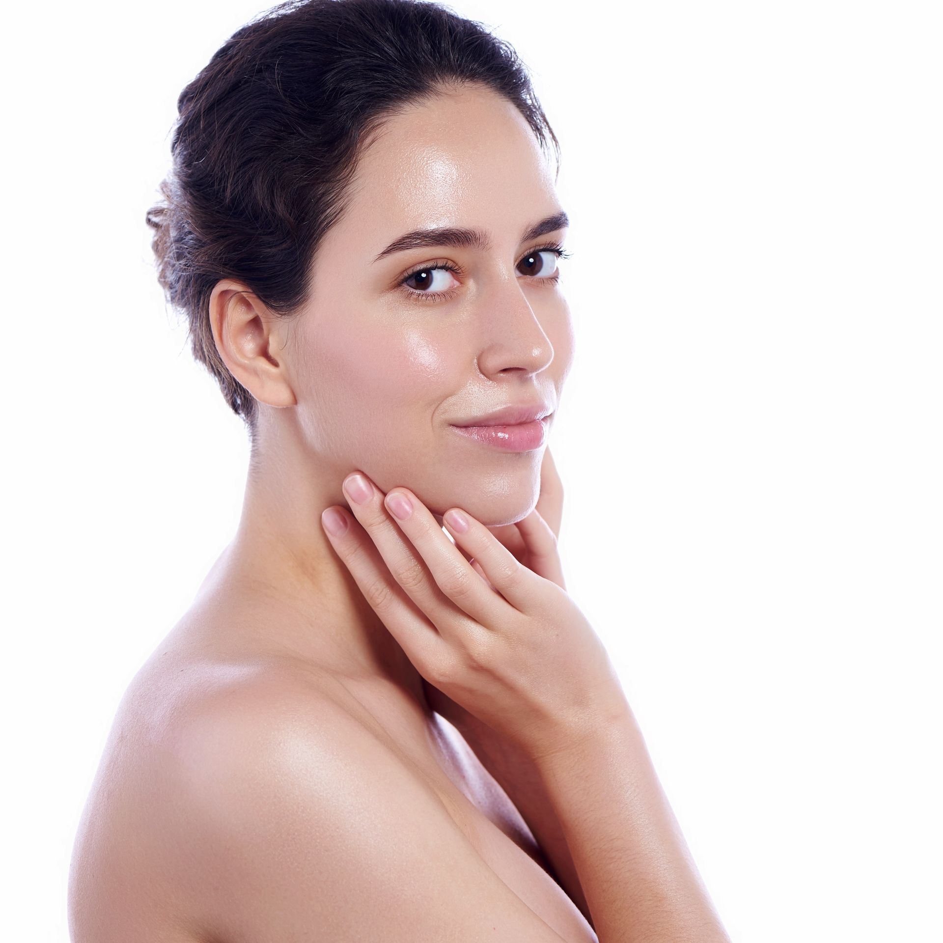 A smiling woman touching her chin with both hands