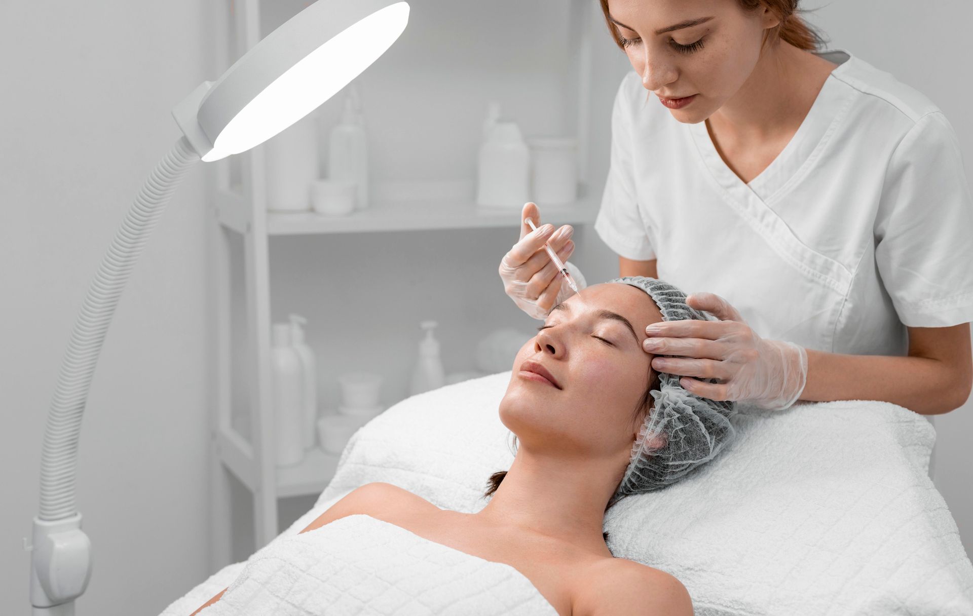 A woman is getting a facial treatment at a beauty salon.