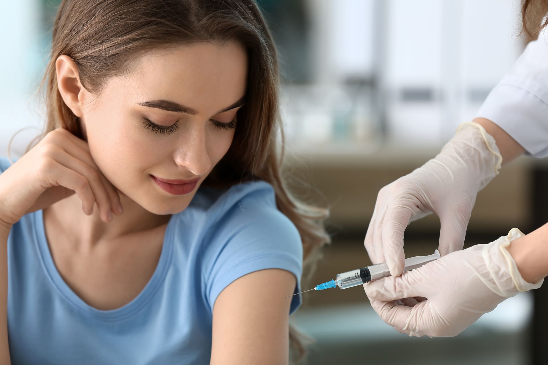 A woman is getting an injection in her arm.