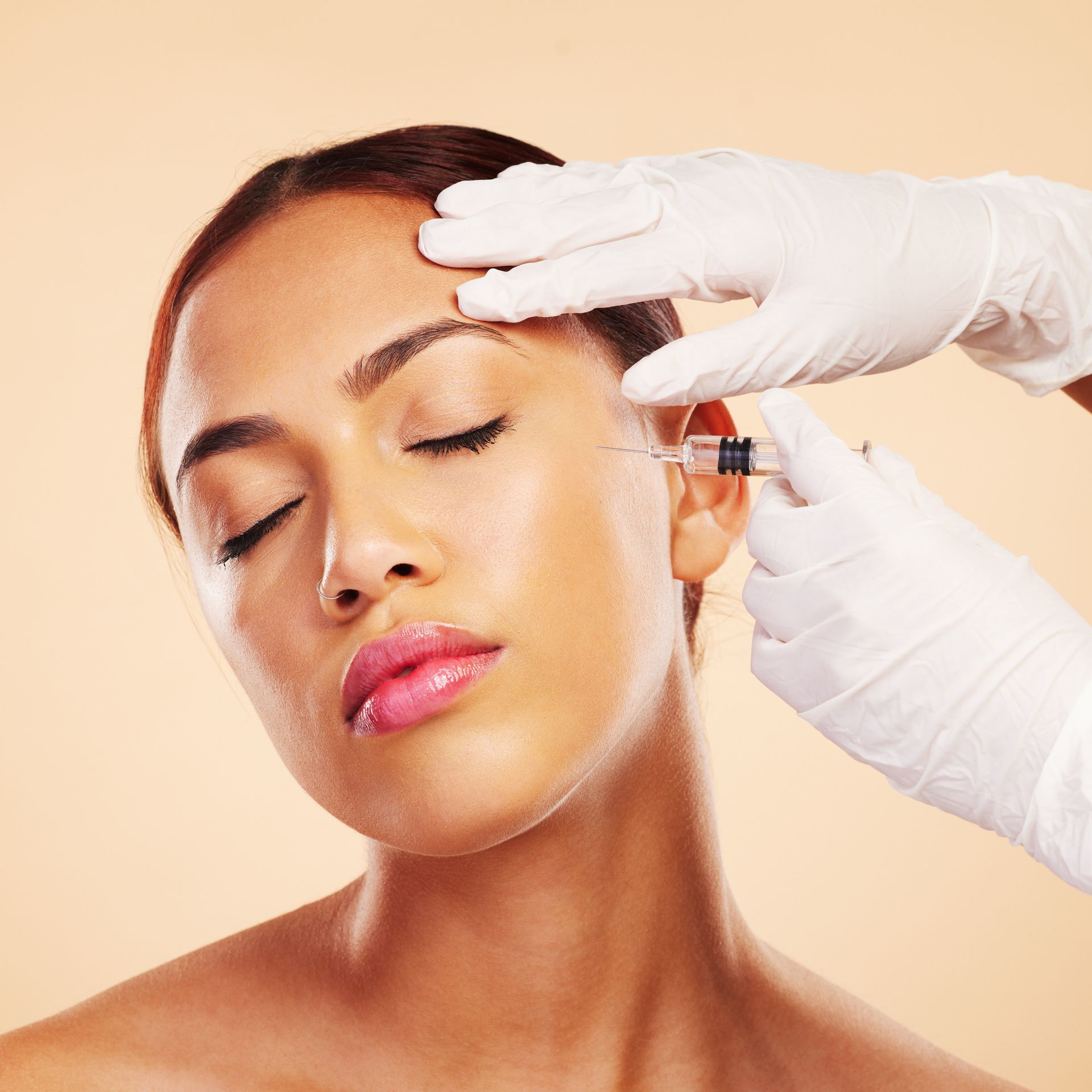 A woman is getting a botox injection in her forehead.