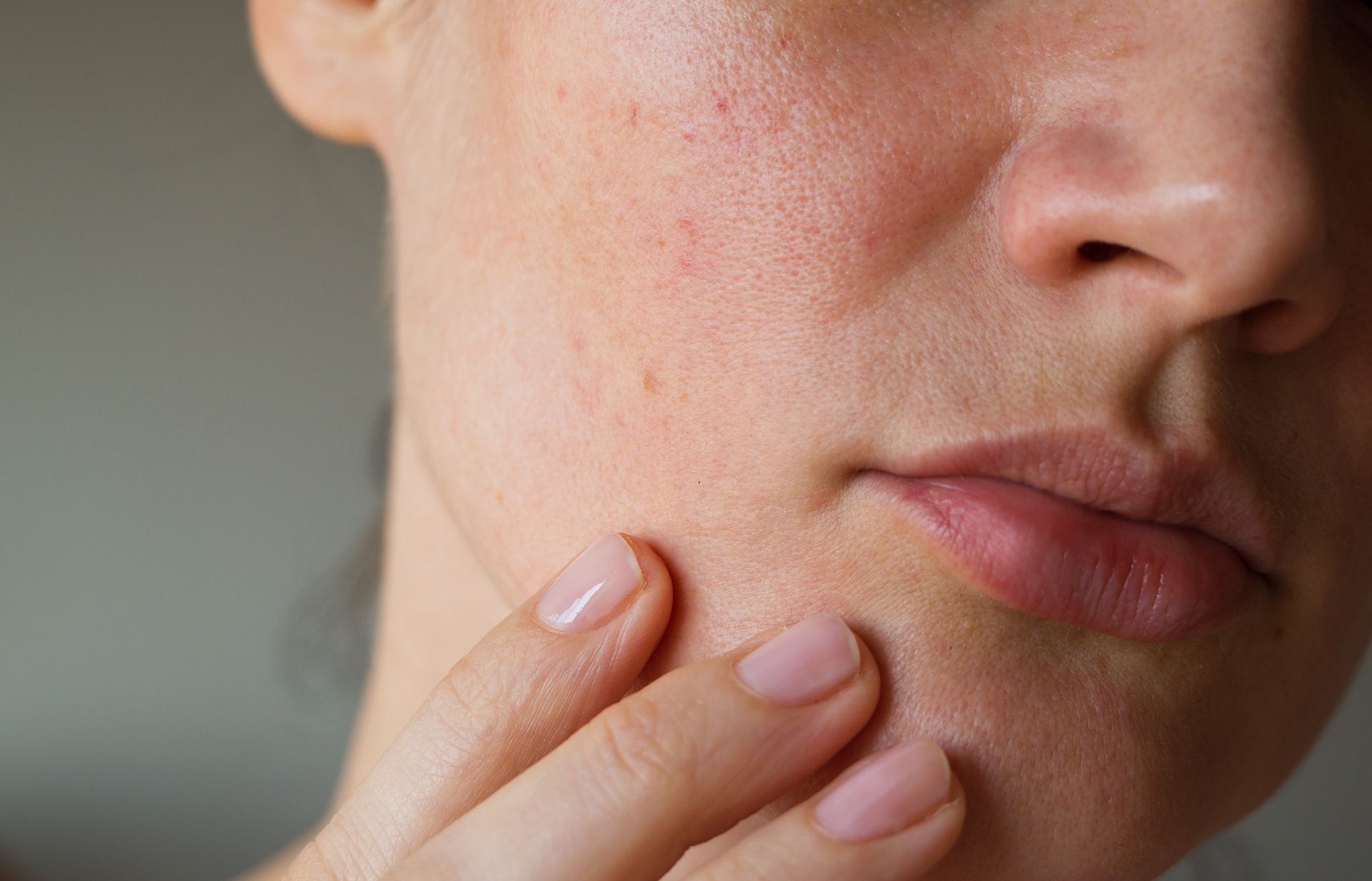 A close up of a woman 's face with a hand on it.