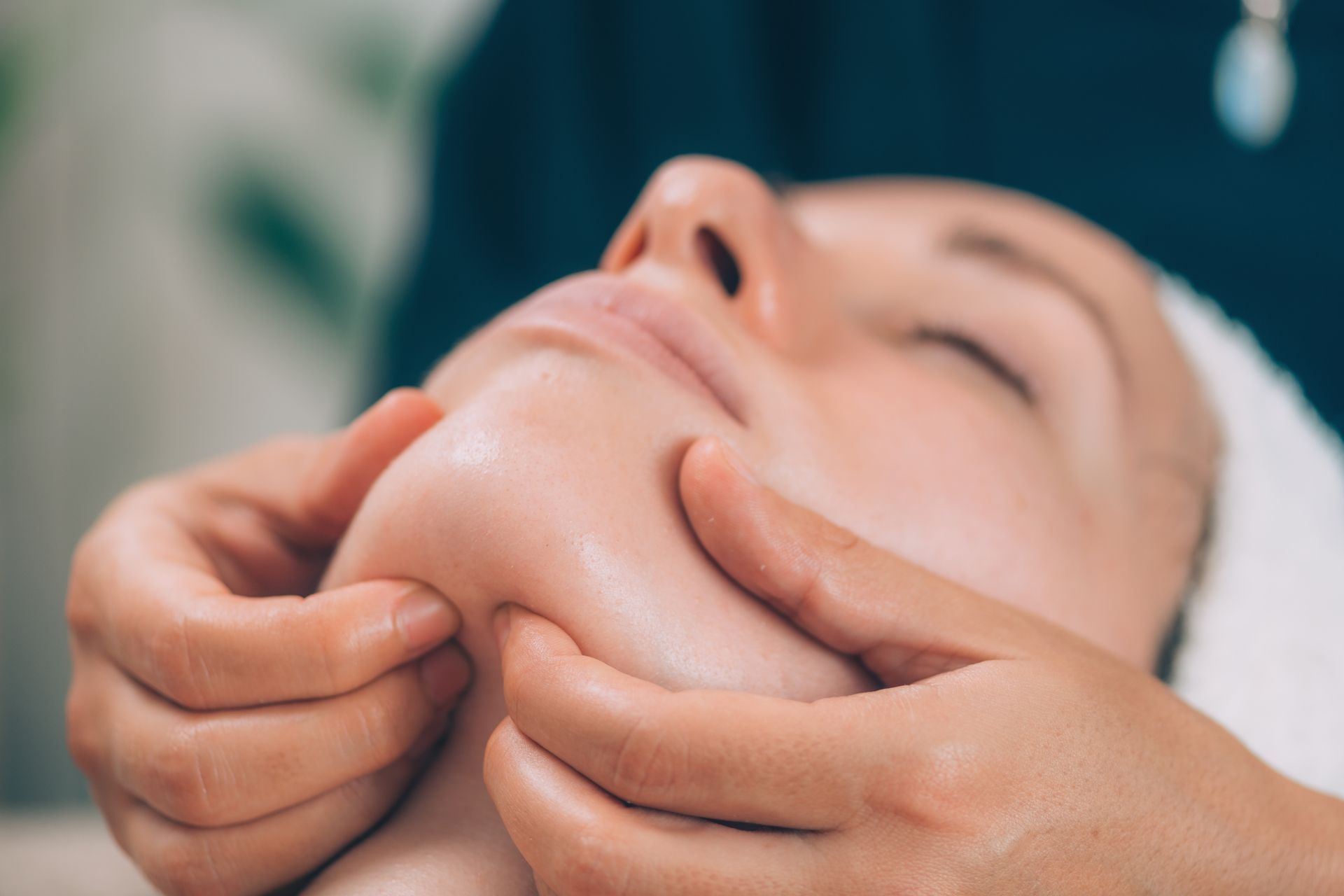 A woman is getting a facial massage at a spa.