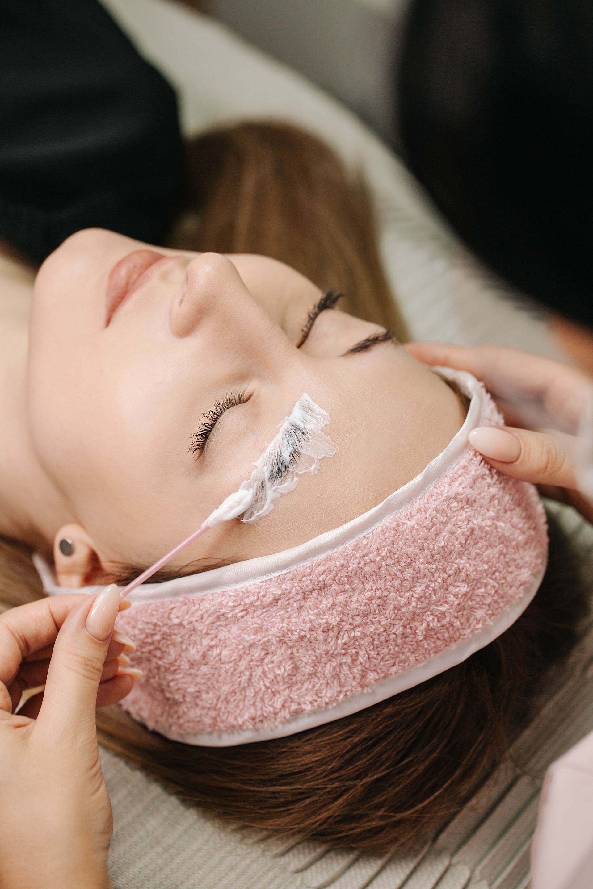 A woman is laying on a bed with a pink headband on her head.