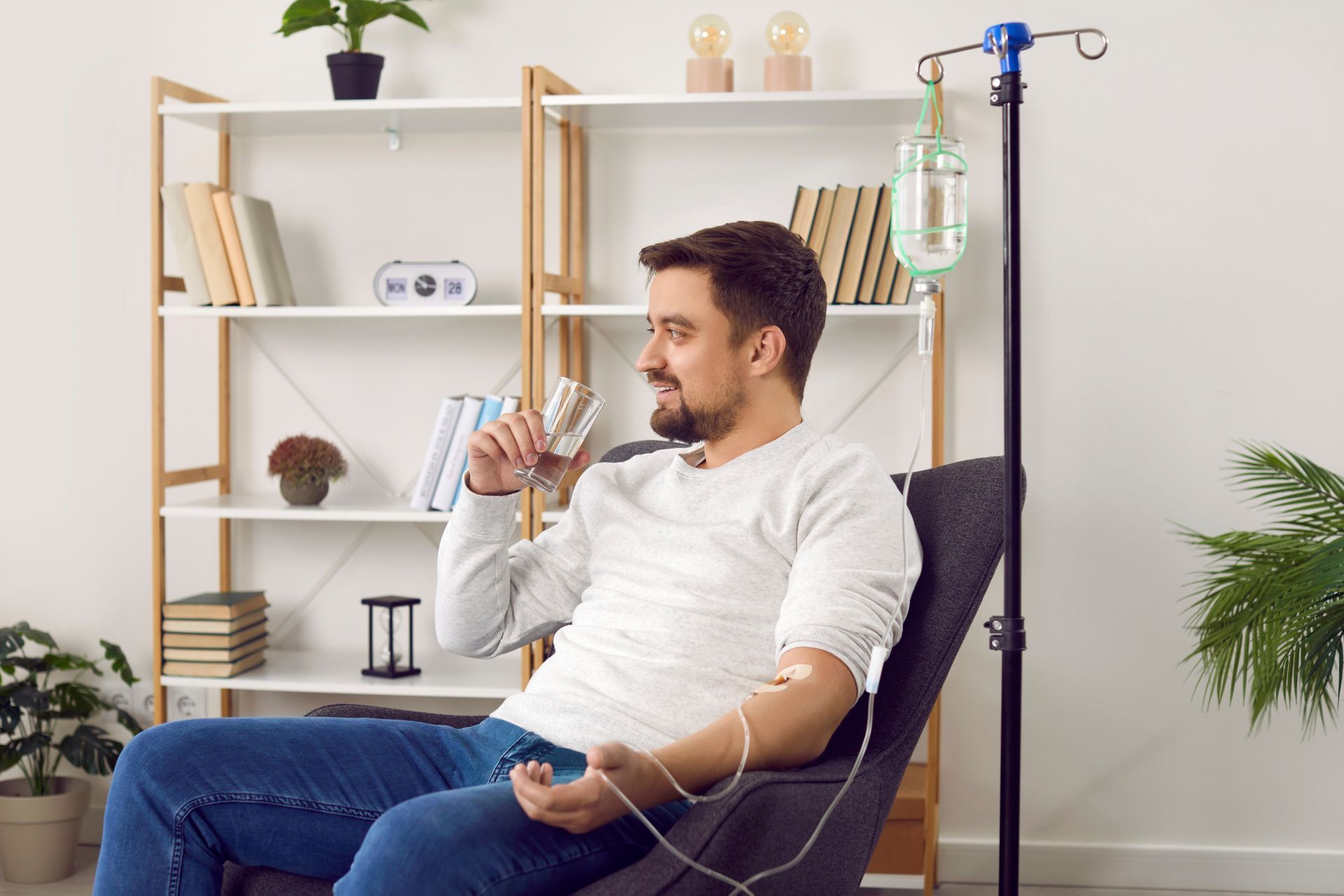 A man is sitting in a chair with an iv in his arm.