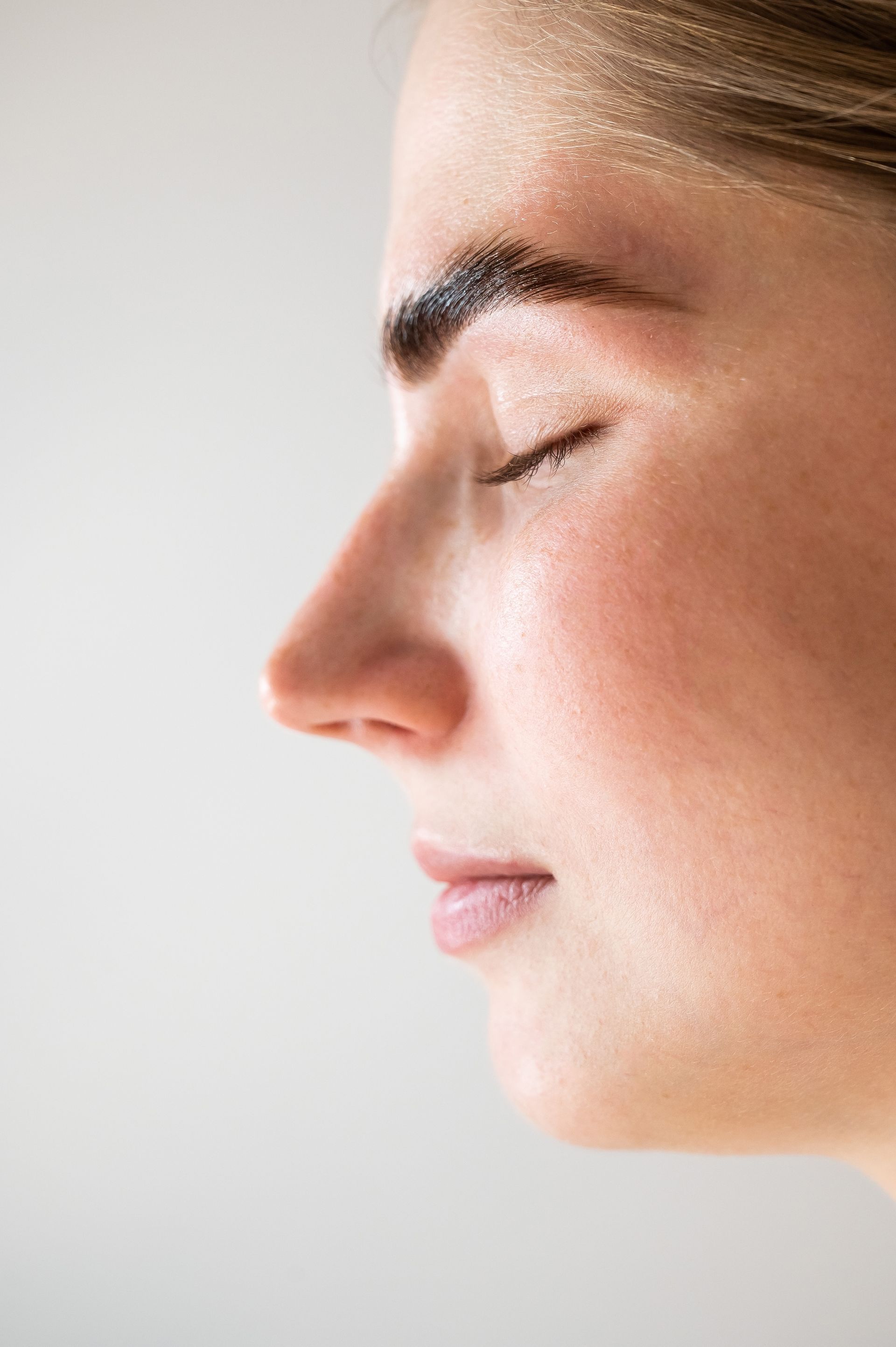 A close up of a woman 's face with her eyes closed.