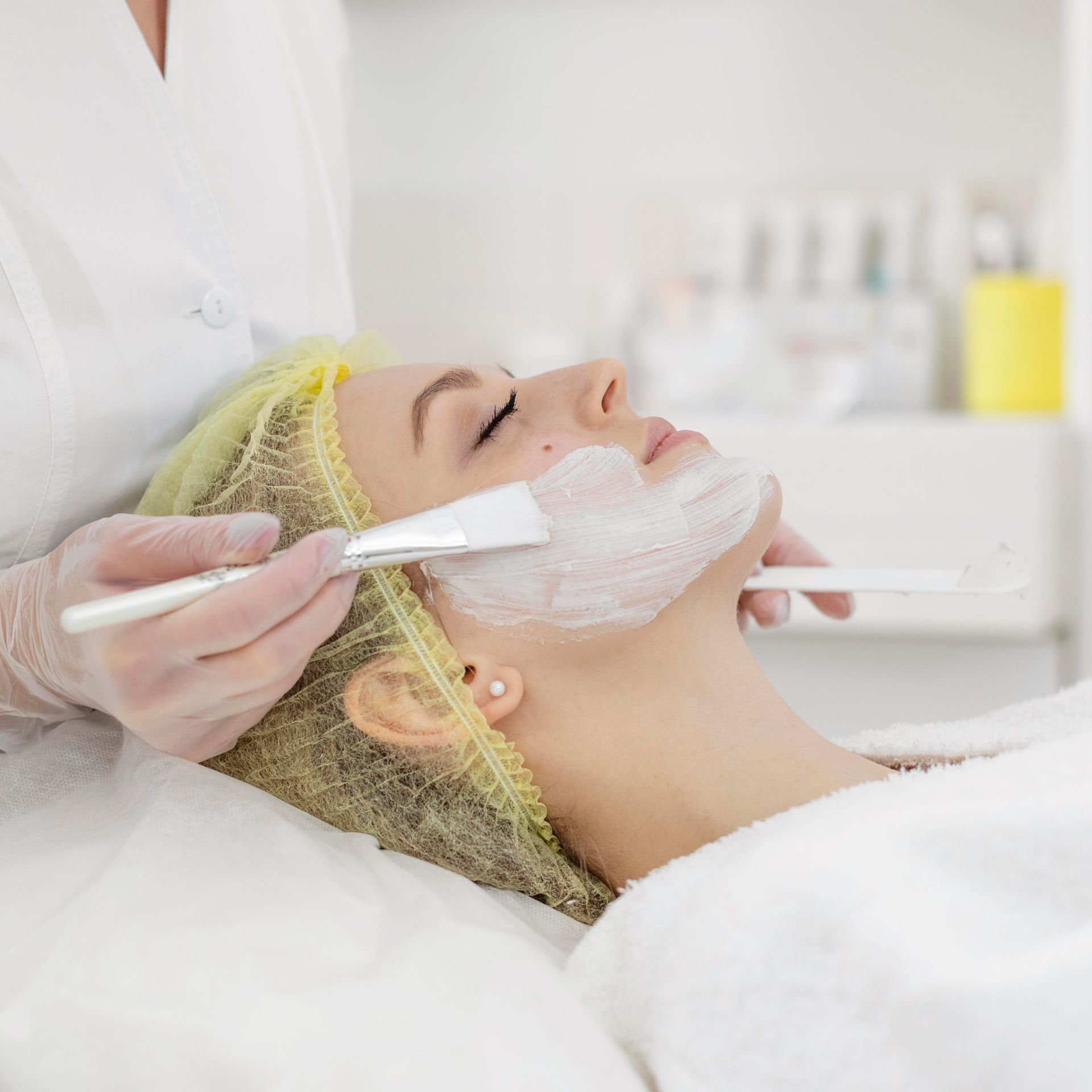 A woman is getting a facial treatment at a beauty salon.